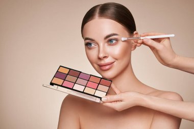 Makyaj sanatçısı Göz Gölgesi 'ni uyguluyor. Güzel Kadın Suratı. Mükemmel makyaj. Makyaj ekibi. Kusursuz Derili Güzellik Kızı. Çivi ve manikür. Göz Gölgesi Paleti