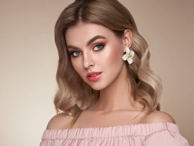 Parlak dalgalı sarı saçlı güzel bir genç kadın. Sağlıklı ciltli bir model, yakın portre. Kozmetik, güzellik ve kaplıca