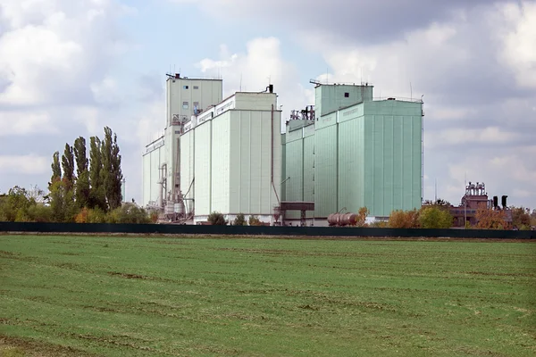 Grain elevator rises among the fields — Stock Photo, Image