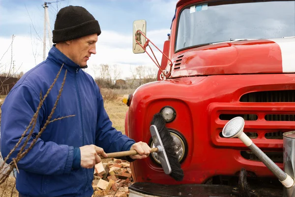 A man washes the old fire truck — Stock Photo, Image