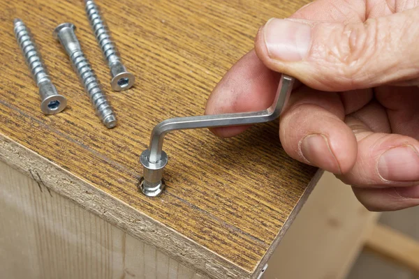 Dra åt skruvarna för hand vid montering av möbler — Stock fotografie