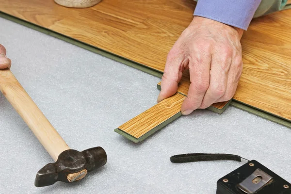 Master trabaja en la colocación de paneles laminados — Foto de Stock