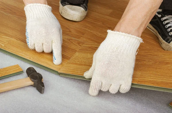 Hands of a master, lay laminate flooring — Stock Photo, Image