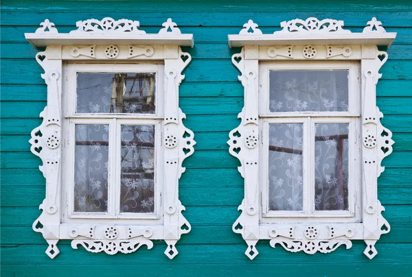 Houten platbands in twee venster van een dorpshuis — Stockfoto