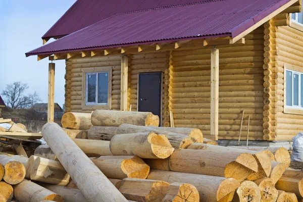 Wooden house and a bunch of logs — Stock Photo, Image