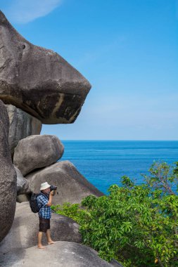 Uçurumun kenarında duran yaşlı bir turist ve Sea Bay 'in fotoğrafları. Tayland