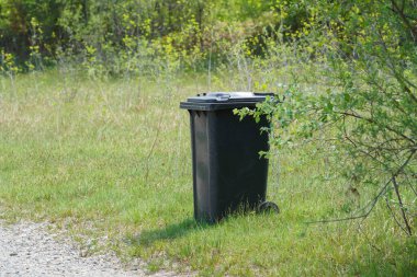 Tipik bir Alman çöp tenekesinin yeşil doğadaki görüntüsü.