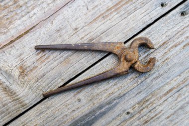 Ahşap arka planda paslı kıskaçların resmi.