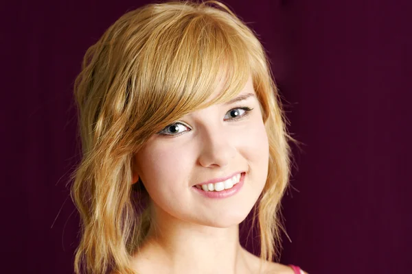 Vriendelijke blonde tiener meisje glimlachen — Stockfoto