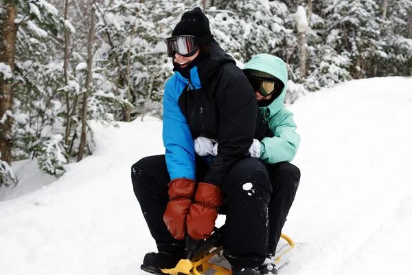 Casal jovem deslizando durante o inverno — Fotografia de Stock