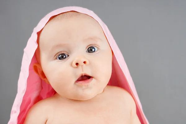 Удивленный новорожденный с розовым одеялом — стоковое фото