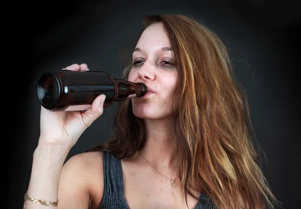 Drunk woman drinking beer over black — Stock Photo, Image