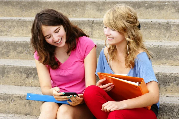 Tieners lachen om mobiele telefoon — Stockfoto