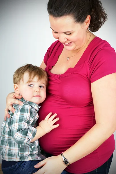 Embarazada mujer abrazando pequeño niño — Foto de Stock