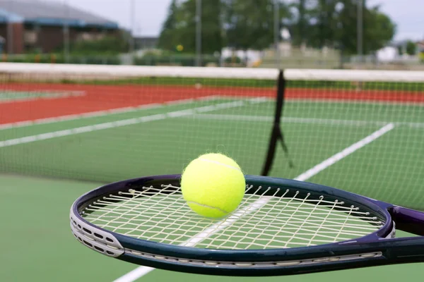 Tennis racket and ball on court — Stock Photo, Image