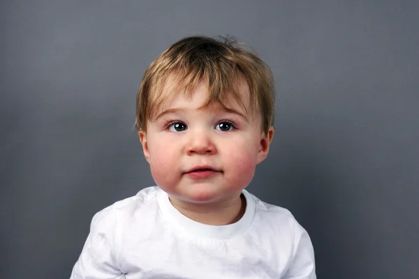 Blonder kleiner Junge über grau — Stockfoto