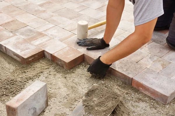 Worker installing paver — Stock Photo, Image