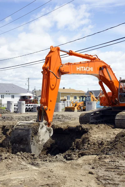 Hitachi turuncu kazıcı ve derin çukur — Stok fotoğraf