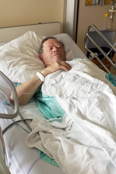 Hombre mayor en cama de hospital — Foto de Stock