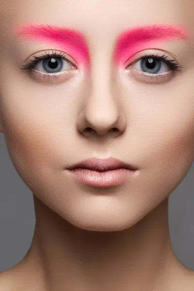 High fashion en schoonheid portretfotografie. mooi meisje model gezicht met creatieve lichte make-up als een pop, schone huid, bleke lippen en levendigheid wenkbrauwen — Stockfoto