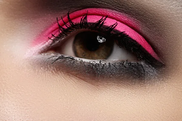 Elegance close-up kadın kutlama parlak renk göz farı gözle. makro çekim güzel kadının yüz bölümü. Sağlık, kozmetik ve makyaj. Sima olarak canlı pembe & siyah renk