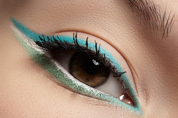 Elegance close-up of beautiful female eye with fashion trend mint colors eyeshadow and eyeliner. Macro shot of beautiful woman's face part with makeup. Cosmetics, beauty and make-up