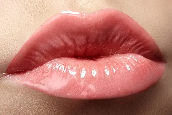 Cosméticos y maquillaje. Primer plano brote de hermosos labios de mujer con lápiz labial rosa y brillo. Maquillaje de labios húmedos sexy. Dulce beso. Primer plano de hermosos labios llenos —  Fotos de Stock
