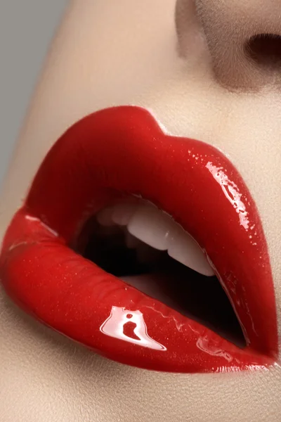 Primer plano de los labios de la mujer con maquillaje brillante rojo de moda. Maquillaje Macro sangriento brillo de labios — Foto de Stock