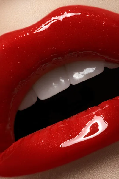 Primer plano de los labios de la mujer con maquillaje brillante rojo de moda. Maquillaje Macro sangriento brillo de labios —  Fotos de Stock