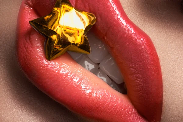 Jasny MAKIJA na usta kobiety. Z bliska rafy piękne usta makijaż. Piękno strzelać makro kobiece usta z gold lucky star. Wizaż doskonały sposób na wakacje — Zdjęcie stockowe