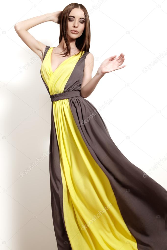 Beautiful luxury woman in fashion long dress with slim waist. Glamour make-up, sexual pose, long straight hair