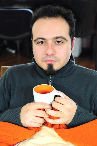 Mann in Decke hält Tasse Tee — Stockfoto