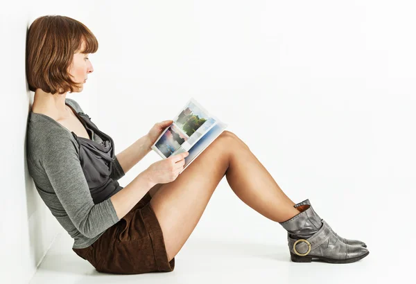 Frau sitzt mit Buch auf dem Boden — Stockfoto