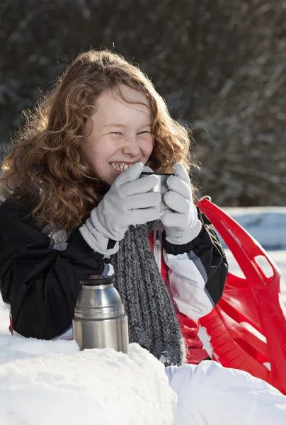 Blond jente som slapper av i en snødekt park – stockfoto