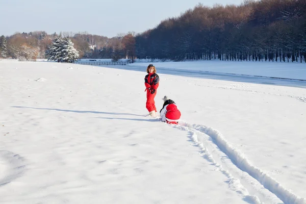 Mor och dotter i snöiga vinter park — Stockfoto