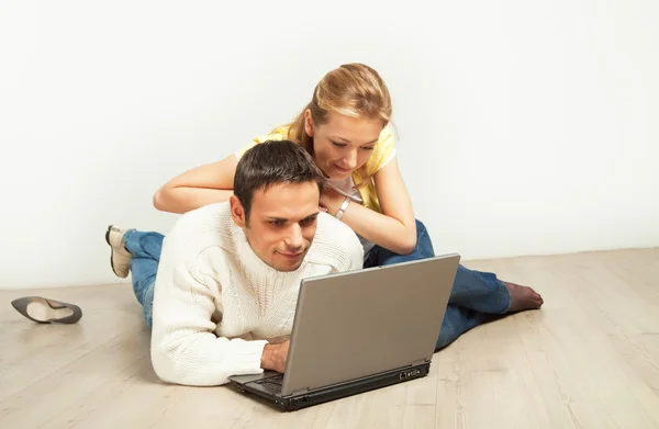 Casal relaxado com computador portátil — Fotografia de Stock