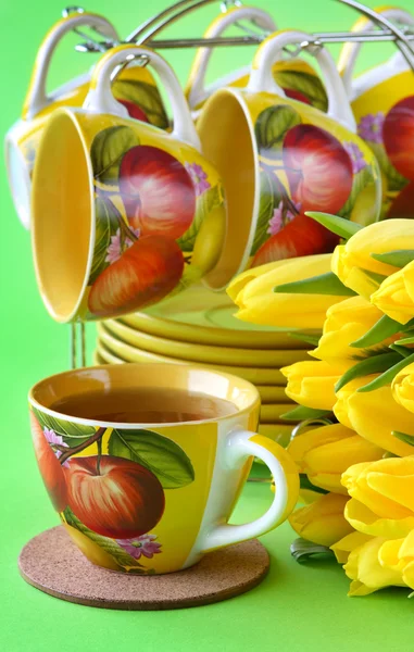 Xícaras de chá e tulipas amarelas — Fotografia de Stock