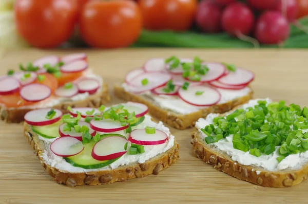 Vier Scheiben Brot mit Quark und Gemüse — Stockfoto