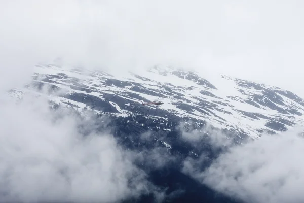 過去の雪に覆われた山の霧の中のヘリコプターします。 — ストック写真