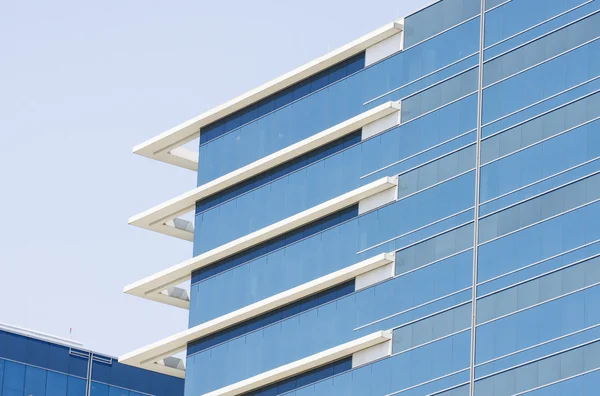 Modré skleněné kancelářské budovy s bílou rohovou střihu — Stock fotografie