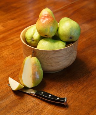 Cut Pear with Pears in Wood Bowl