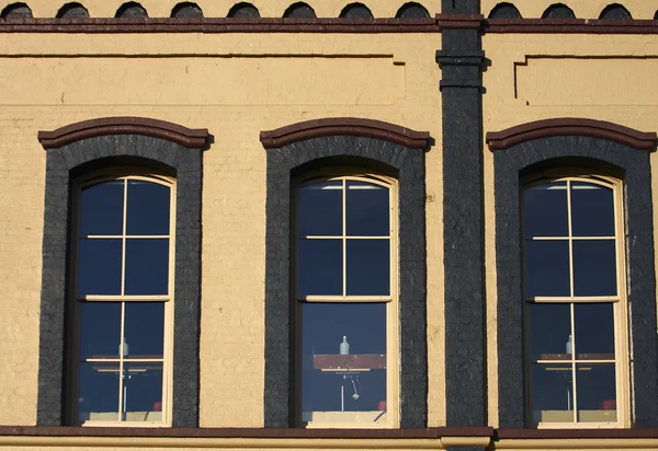 Три окна с тёмной кирпичной отделкой — стоковое фото