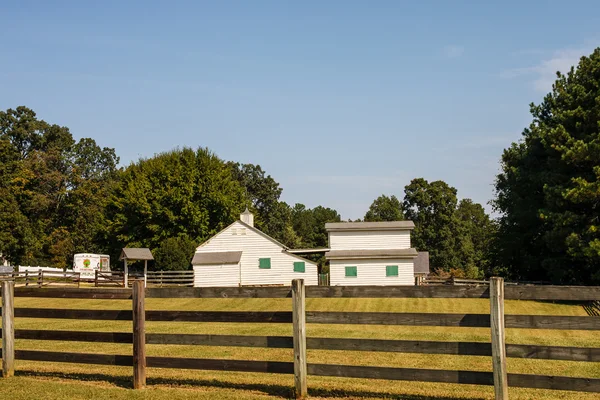 Yellow Barns with Green Shutters Past Fence — Stock Photo, Image