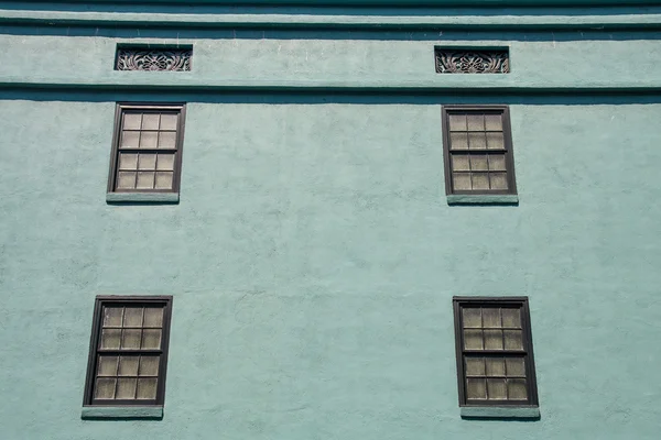 Alte Fenster in grüner Putzwand — Stockfoto