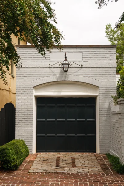 Garage en brique blanche avec porte noire — Photo