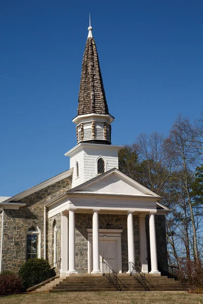 Vecchia chiesa di pietra con faccia di legno bianco — Foto Stock