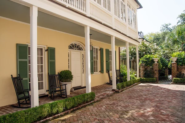 Baksteen veranda op geel en groen huis — Stockfoto