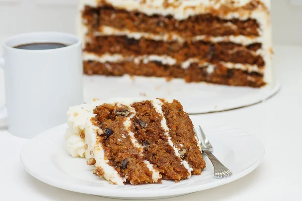 Rebanadas y medio pastel de zanahoria en blanco con taza de café —  Fotos de Stock