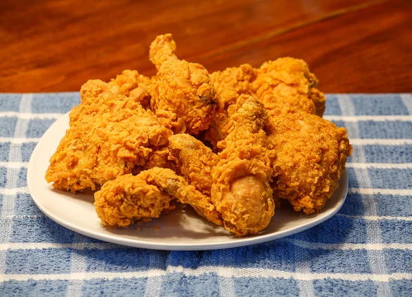 Frisches gebratenes Huhn auf blau kariertem Tischset — Stockfoto