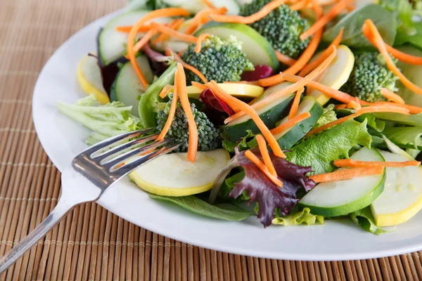 Свежий овощной салат на белой плите с вилкой — стоковое фото